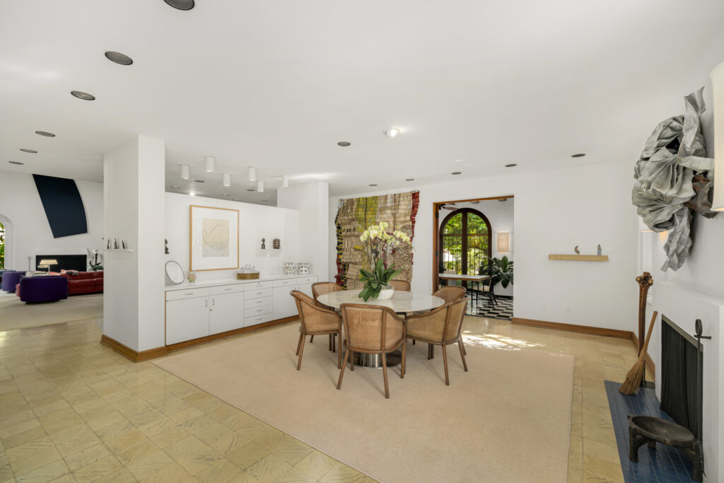 The formal dining area blends modern comfort with refined character, featuring custom cabinetry, curated art, and natural light through arched French doors.